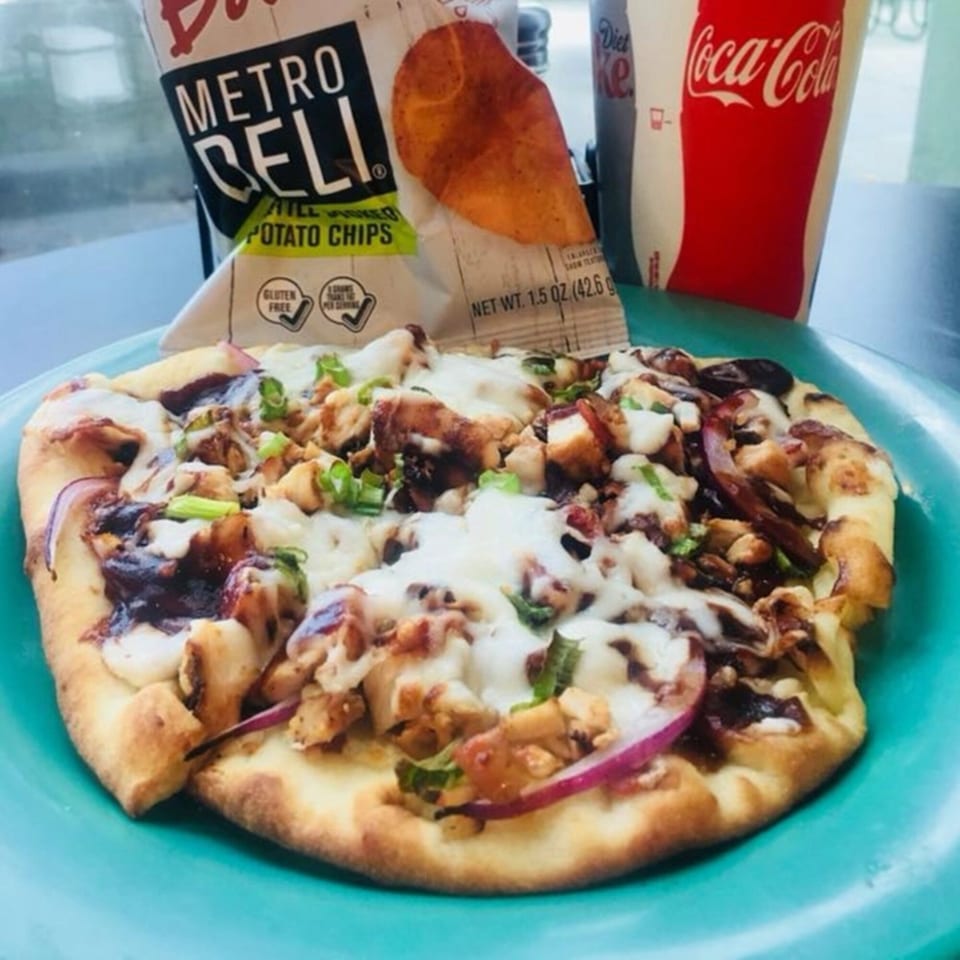 Knickerbockers Deli's BBQ chicken flatbread pizza with chips and a Coca-Cola drink.