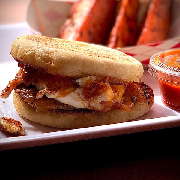 Knickerbockers Deli breakfast sandwich with egg, cheese, and bacon on an English muffin.