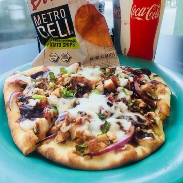 Knickerbockers Deli BBQ chicken flatbread pizza with chips and a Coca-Cola.